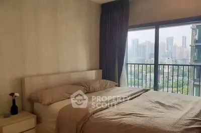 Cozy bedroom with city view and large window, perfect for urban living.