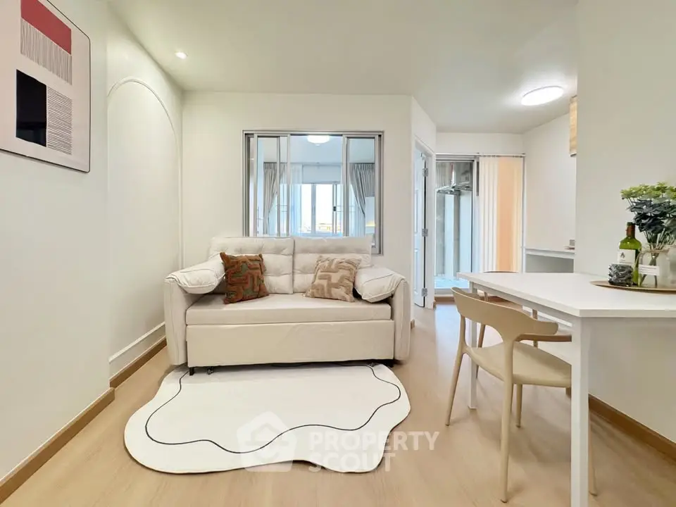 Modern living room with cozy white sofa and dining area in stylish apartment.