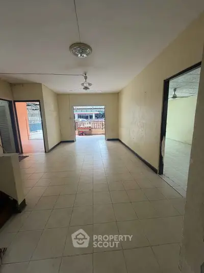 Spacious open-plan living area with tiled flooring and ceiling fan, ideal for family gatherings.