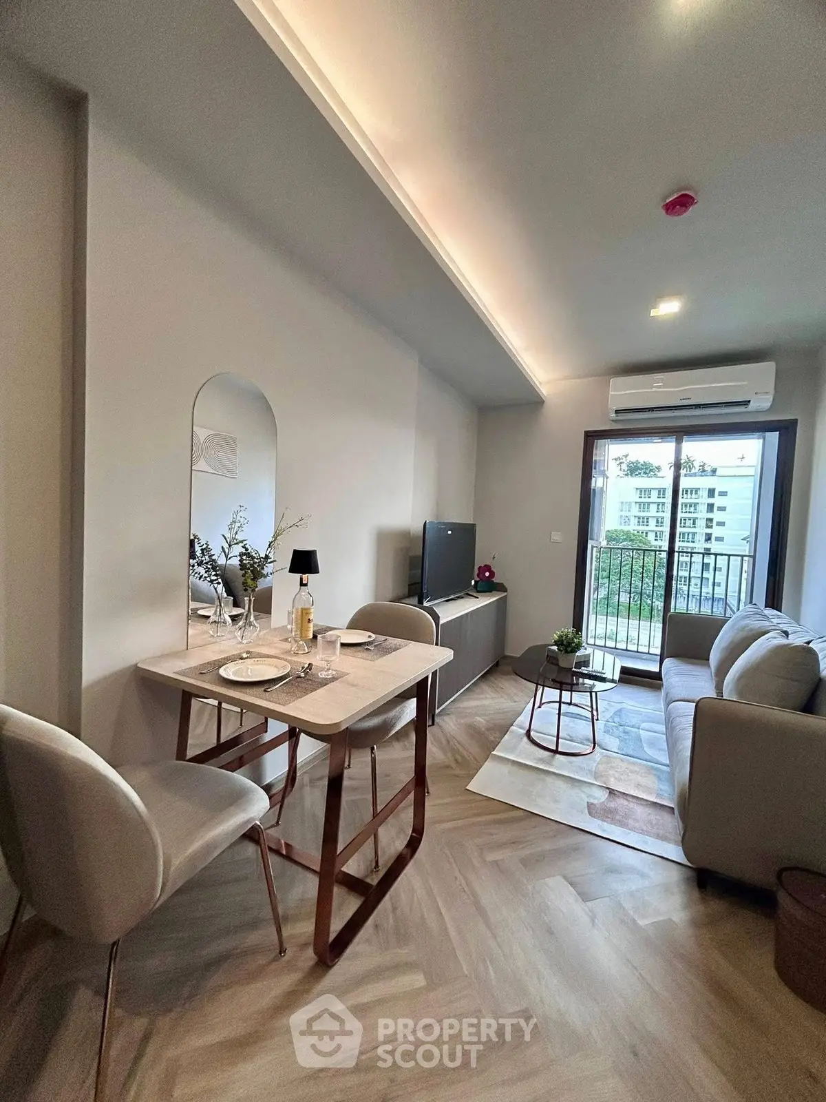 Modern living room with dining area and balcony view in stylish apartment.
