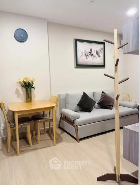 Cozy living room with modern decor, featuring a comfortable sofa, dining table, and stylish coat rack.