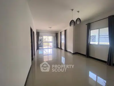 Spacious modern living room with large windows and elegant lighting fixtures.