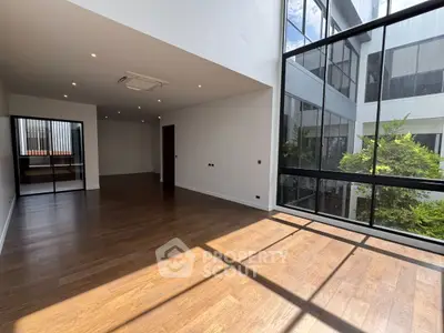 Spacious modern living room with large windows and wooden flooring