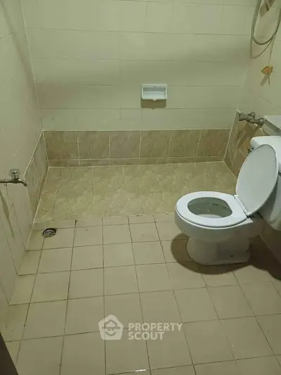 Simple bathroom with tiled floor and basic fixtures, ideal for budget-friendly homes.