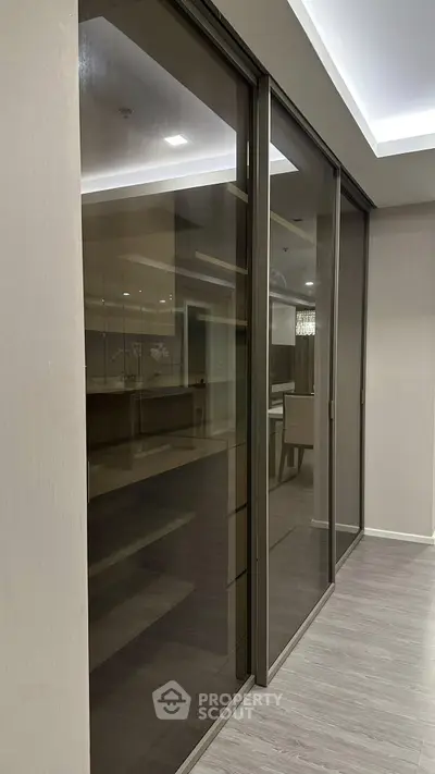 Modern interior with glass sliding doors and elegant dining area, featuring sleek design and ambient lighting.