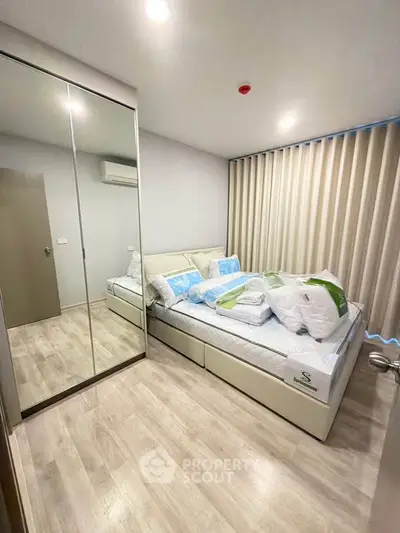 Modern bedroom with mirrored wardrobe and stylish decor in a cozy apartment.