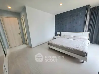 Spacious modern bedroom with stylish decor and ample natural light