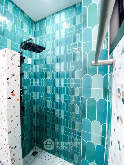 Stylish modern shower with vibrant teal tiles and sleek fixtures