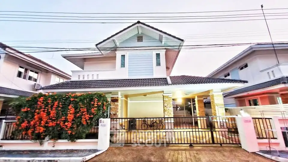 Charming two-story house with modern facade and lush garden in a serene neighborhood.
