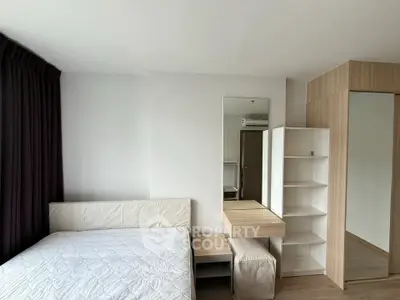 Modern bedroom with minimalist design, featuring a cozy bed, sleek mirror, and ample storage space.