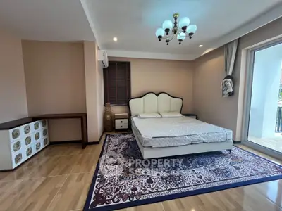 Spacious bedroom with elegant decor and large window access to balcony