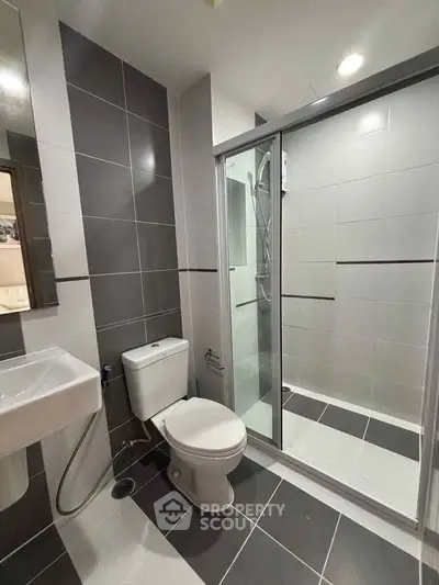 Modern bathroom with sleek design featuring glass shower and stylish tiles.