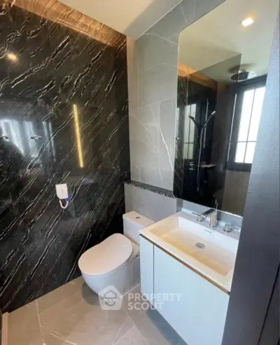 Luxurious modern bathroom with sleek marble walls and contemporary fixtures.