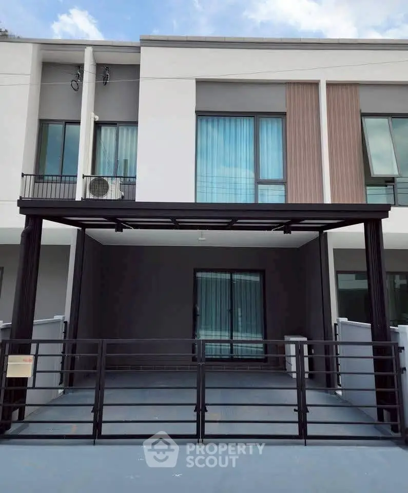 Modern townhouse exterior with sleek design and gated parking area, perfect for urban living.