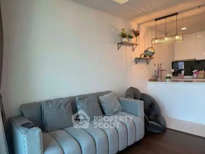 Stylish living room with modern sofa and open kitchen layout, perfect for cozy gatherings.