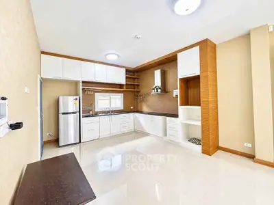 Spacious modern kitchen with sleek cabinetry and stainless steel appliances in a bright open layout.