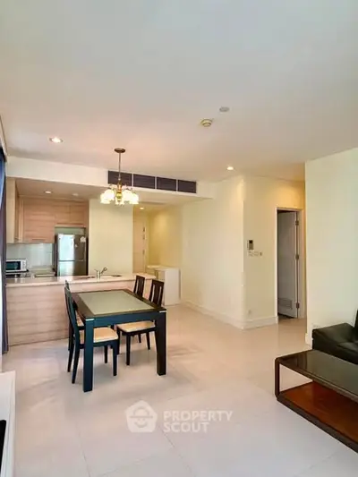 Spacious open-plan living and dining area with modern kitchen in a bright apartment.
