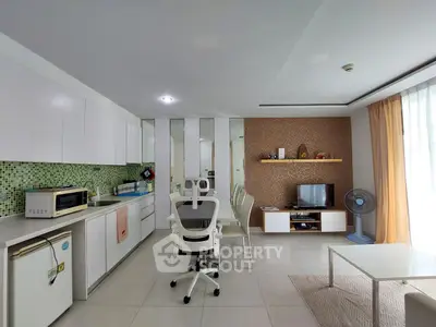 Modern open-layout kitchen and living room with sleek white cabinets and stylish decor.