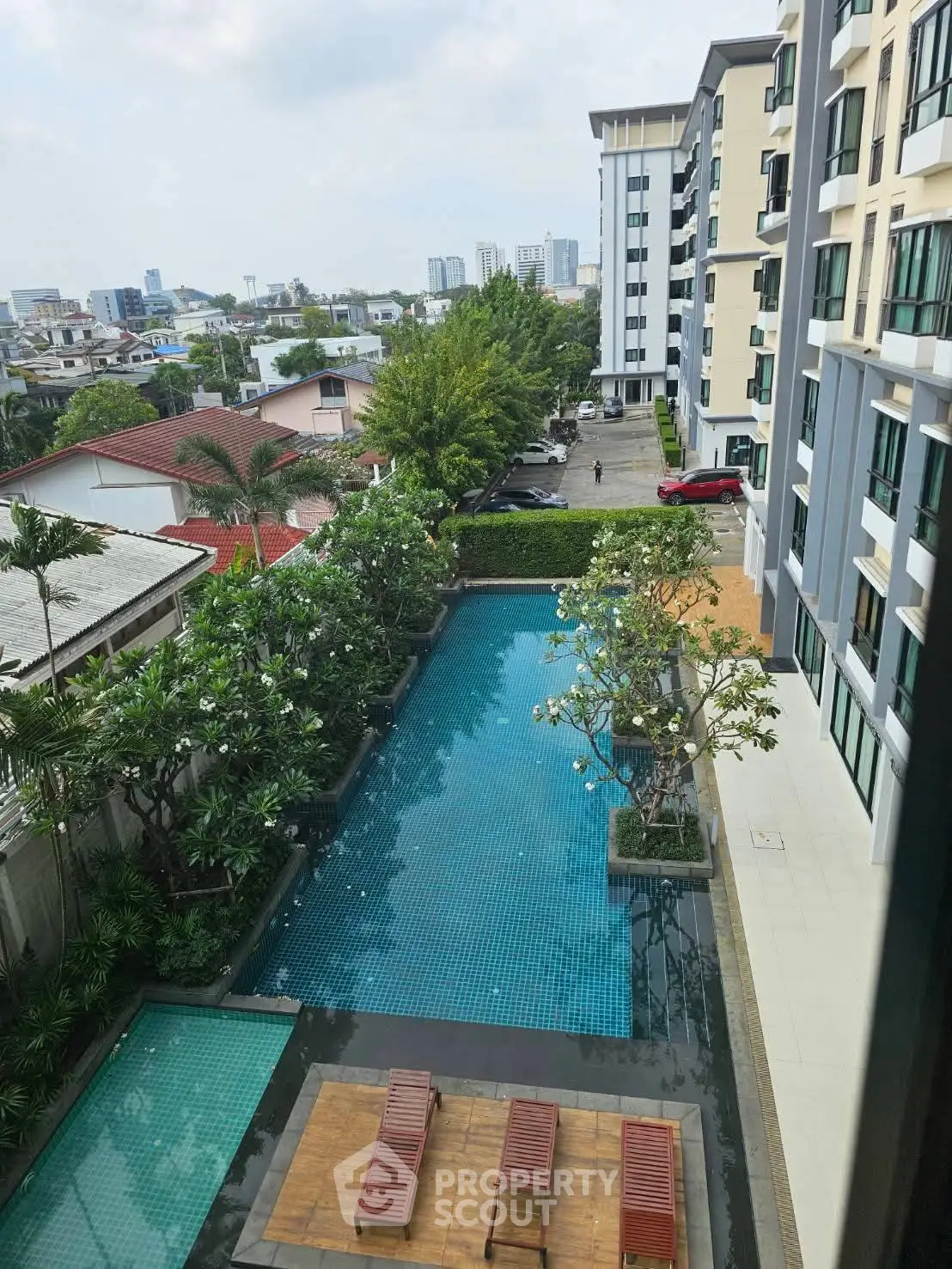 Luxurious apartment view with pool and lush greenery in urban setting