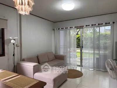 Cozy living room with garden view, featuring a comfortable sofa and elegant decor.