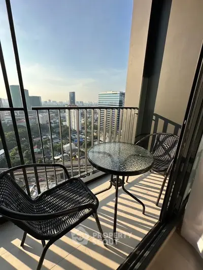 Chic urban balcony with stunning city view and stylish outdoor seating.