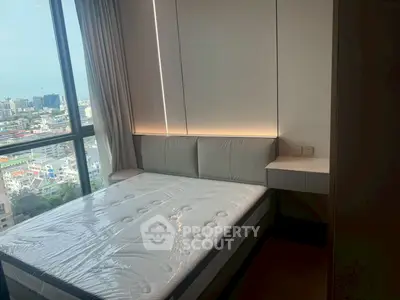 Modern bedroom with city view, featuring a sleek design and large windows for natural light.