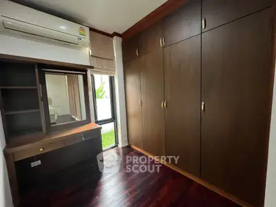 Spacious bedroom with wooden wardrobe and air conditioning in modern home