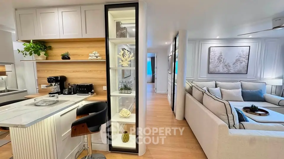 Modern open-plan kitchen and living room with stylish decor and cozy seating area.