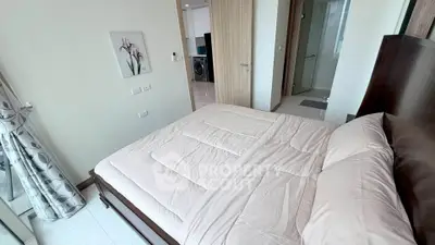 Spacious bedroom with modern decor and ensuite bathroom in a luxury apartment.