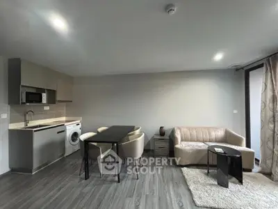Modern open-plan living room with sleek kitchen and cozy seating area, perfect for urban living.