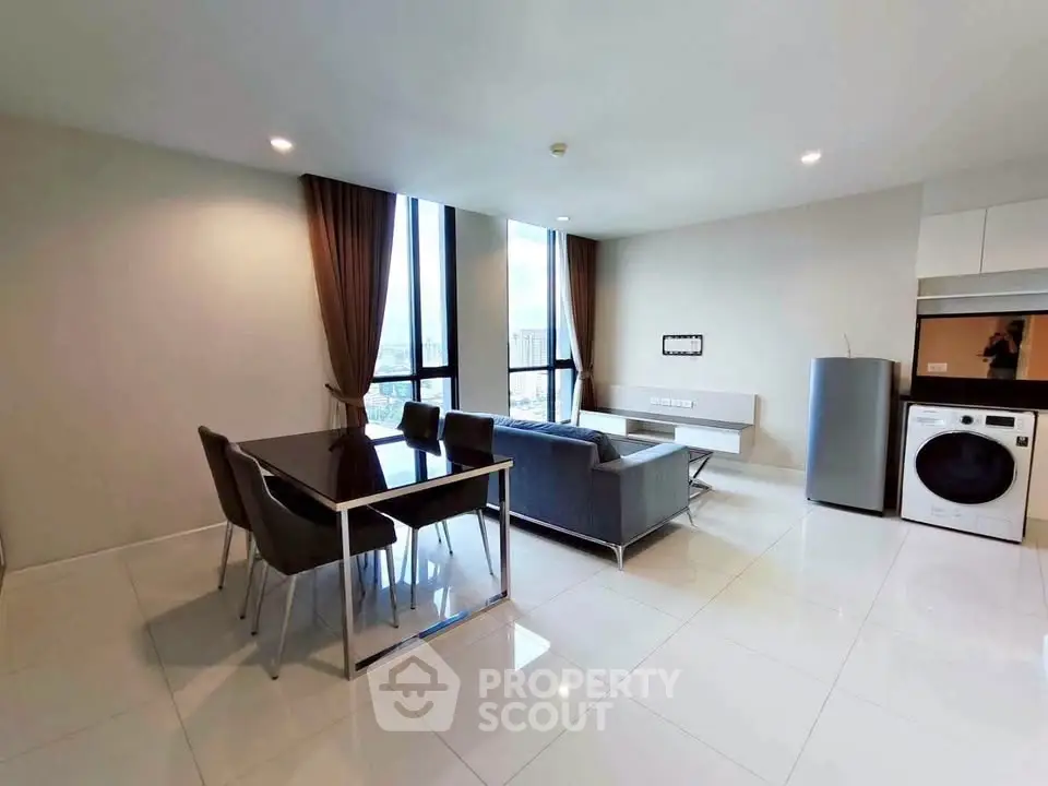 Modern living room with dining area and appliances in a bright, open space.