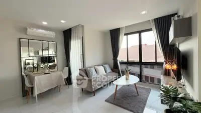 Modern living room with stylish decor and large windows offering natural light.