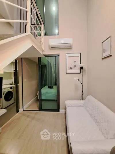 Modern loft apartment with mezzanine, cozy living area, and sleek design
