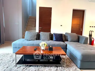 Modern living room with stylish gray sofa and wooden coffee table in a cozy interior setting.