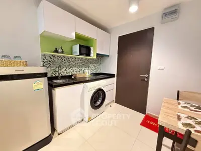 Modern kitchen with washing machine and microwave in compact layout