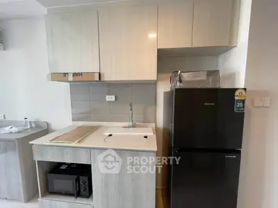 Modern kitchen with sleek cabinetry and compact appliances in a stylish apartment.