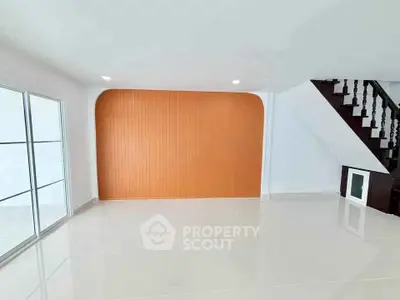 Spacious modern living room with sleek staircase and vibrant accent wall