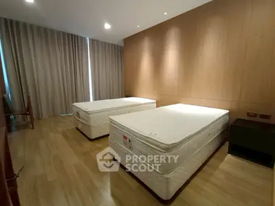 Spacious bedroom with twin beds and elegant wooden flooring