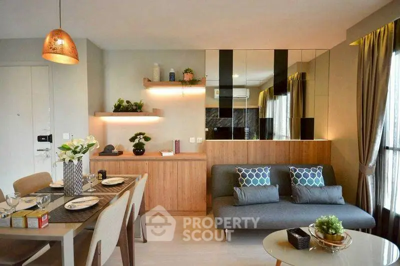 Modern living room with stylish decor and dining area, featuring cozy sofa and elegant lighting.