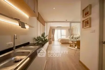 Modern open-layout apartment with sleek kitchen and cozy living area, perfect for urban living.