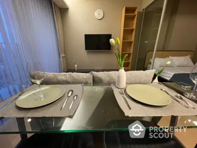 Modern dining area with elegant table setting and cozy bedroom view in a stylish apartment.