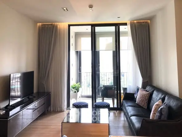 Modern living room with sleek furniture and balcony view in upscale apartment.