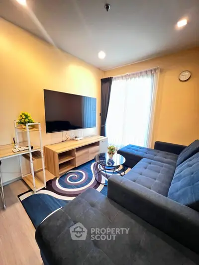 Modern living room with stylish furniture and large TV, perfect for relaxation and entertainment.