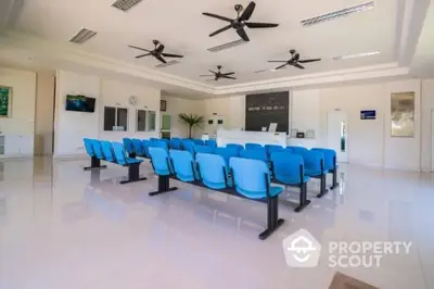 Spacious modern waiting area with blue seating and ceiling fans