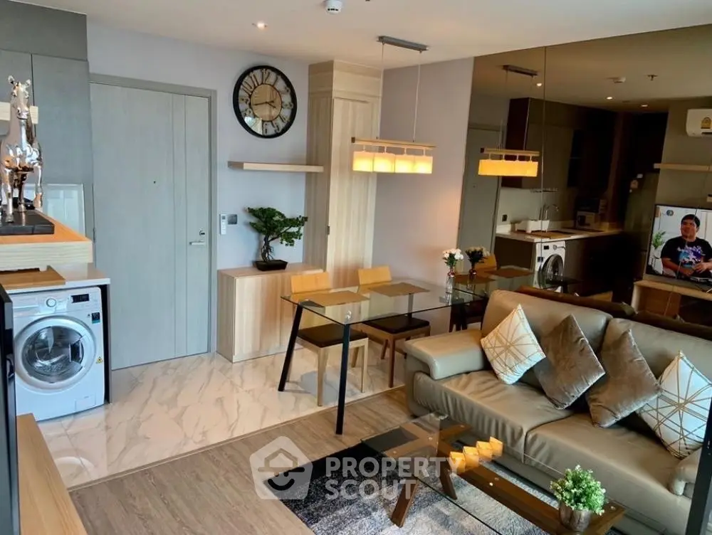 Modern living room with stylish decor, open layout, and in-unit washing machine.