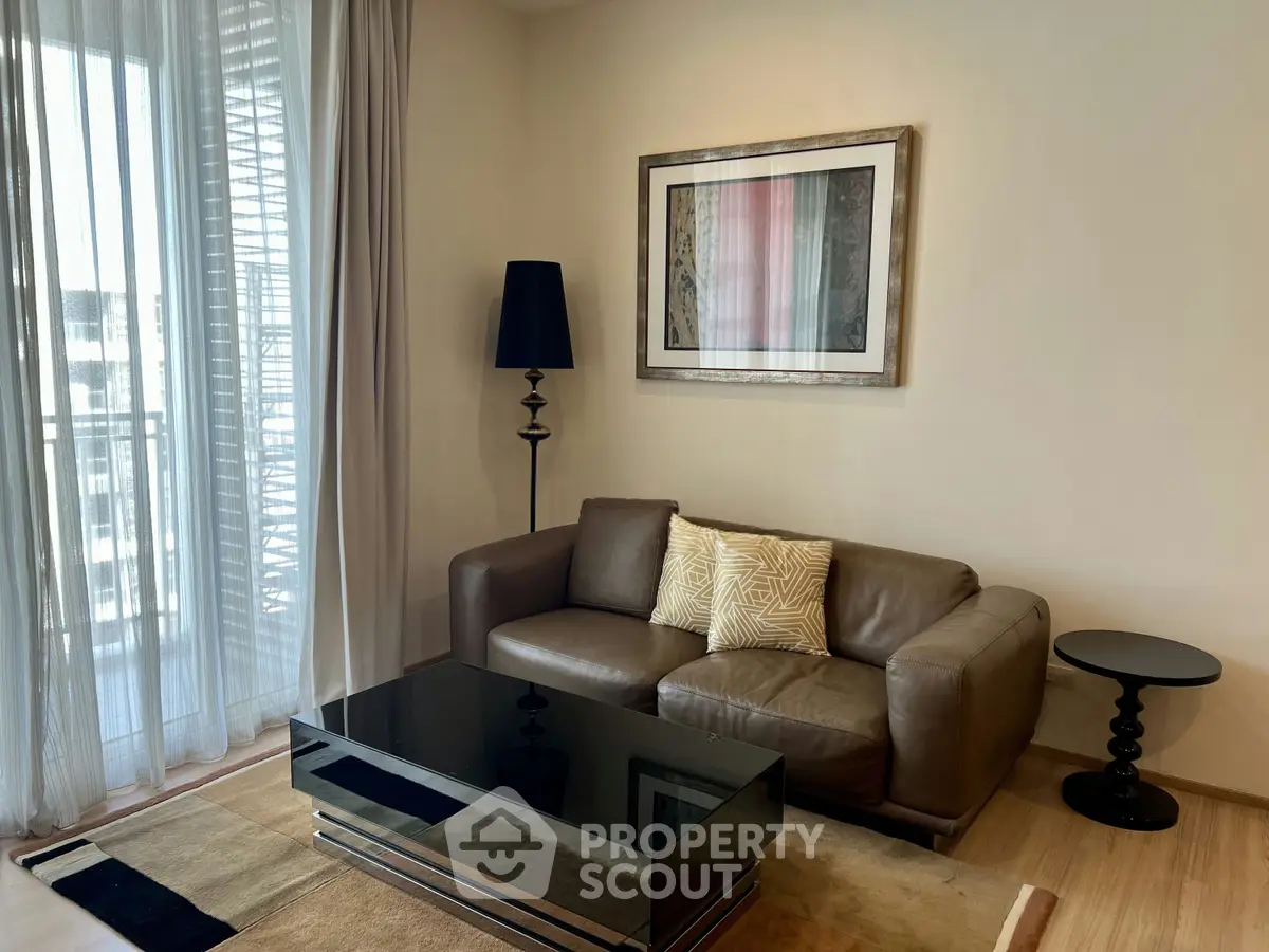 Stylish living room with modern decor and large window offering natural light.