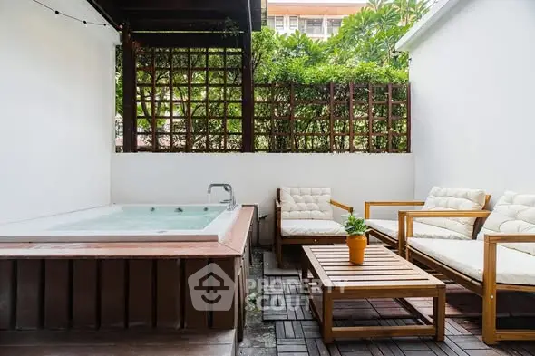 Charming outdoor patio with jacuzzi and cozy seating area, perfect for relaxation.