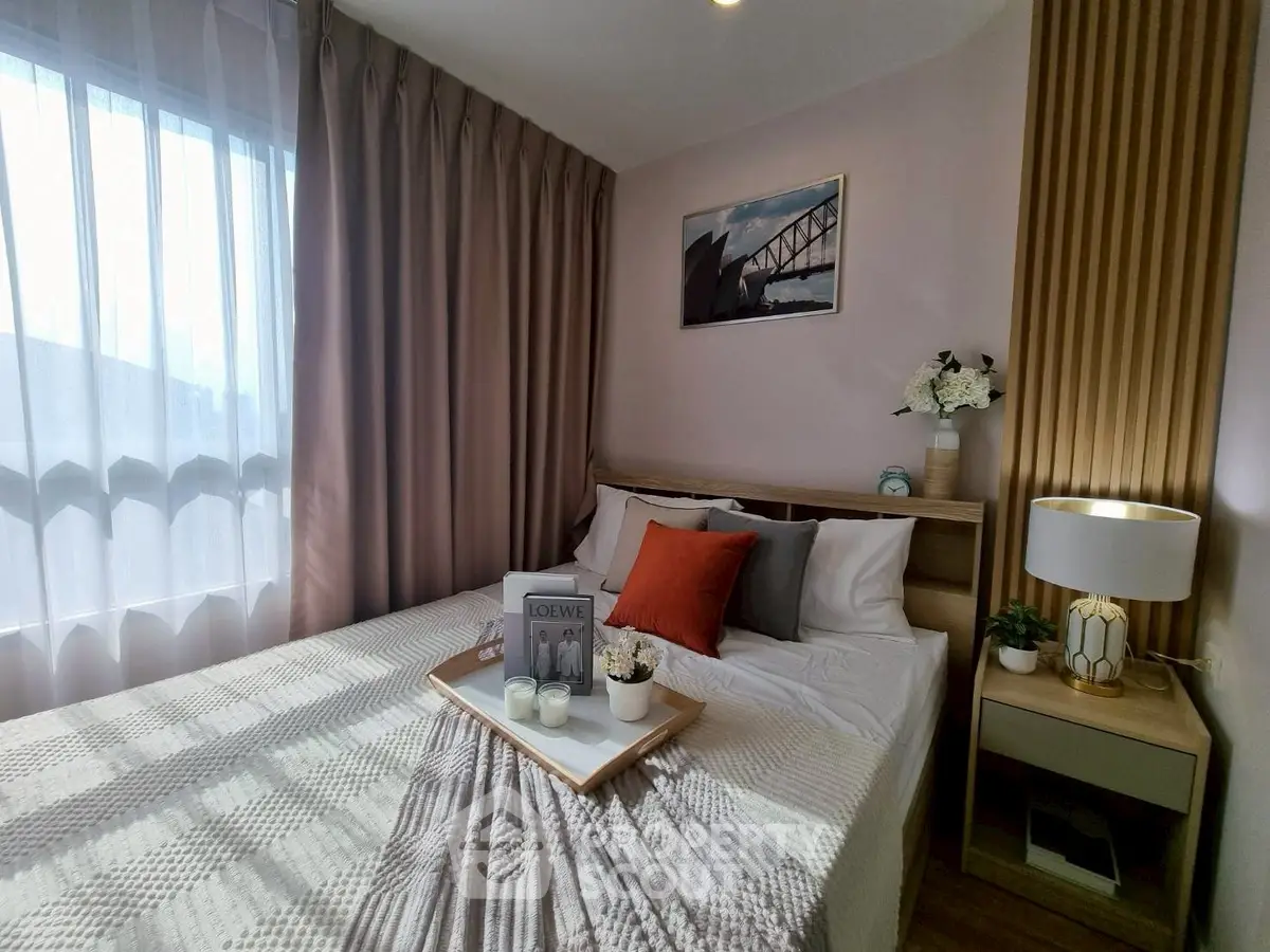 Cozy bedroom with elegant decor and natural light, featuring a stylish bed and modern nightstand.