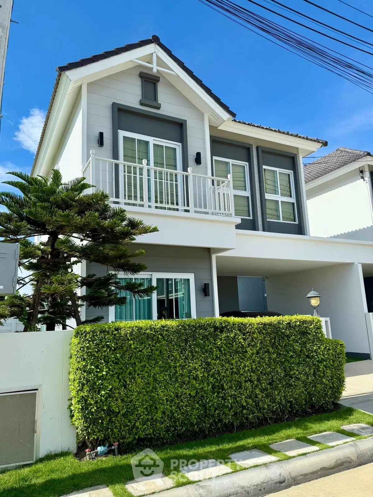 Charming two-story house with modern design and lush greenery, perfect for family living.