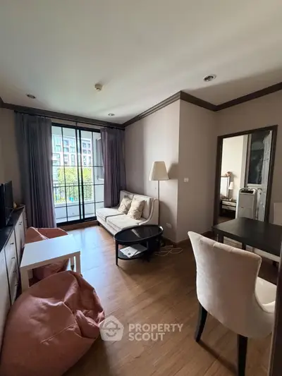 Cozy living room with balcony view, modern furniture, and natural light.